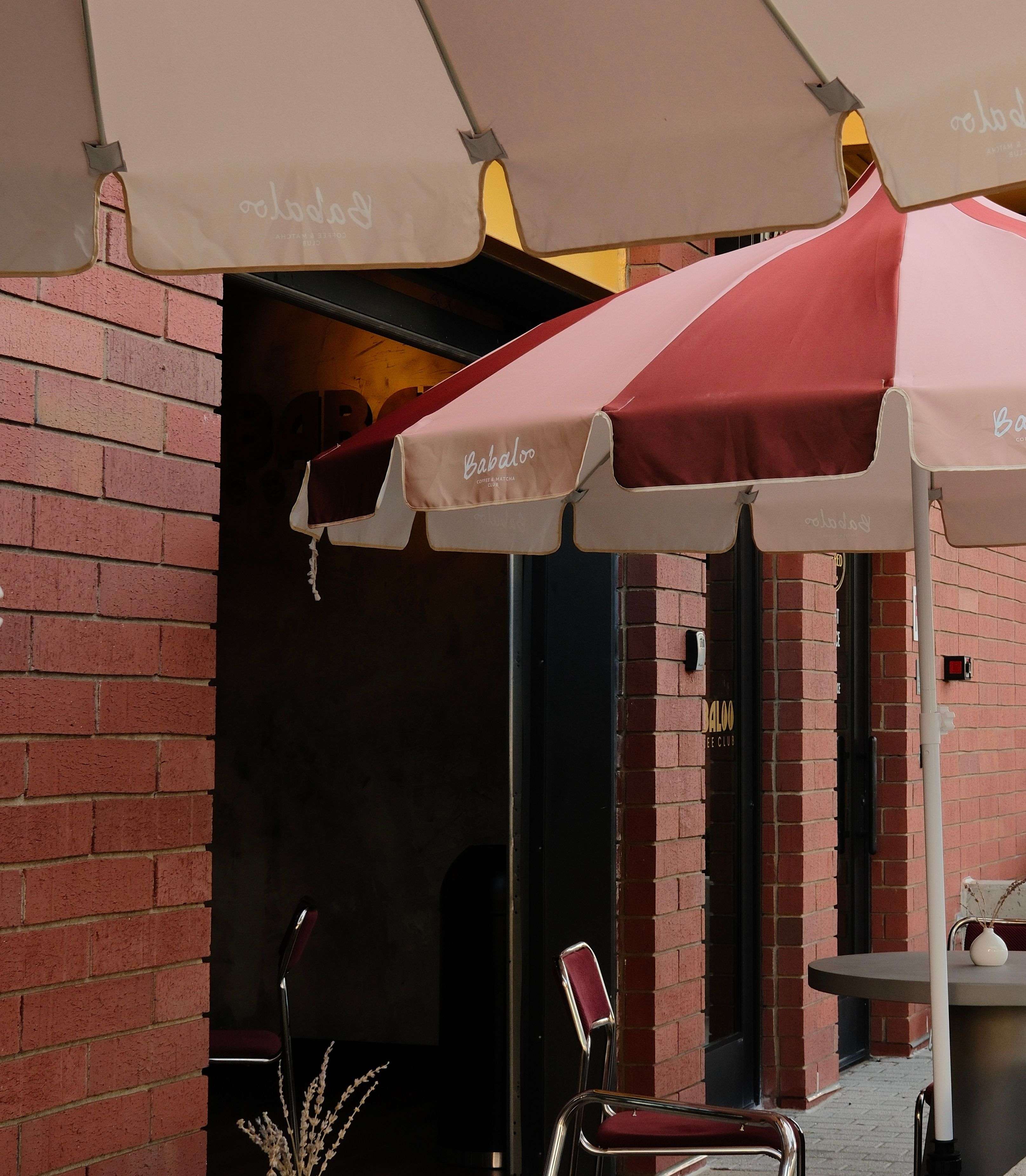 A guest walking down the sidewalk with a Babaloo coffee in hand
