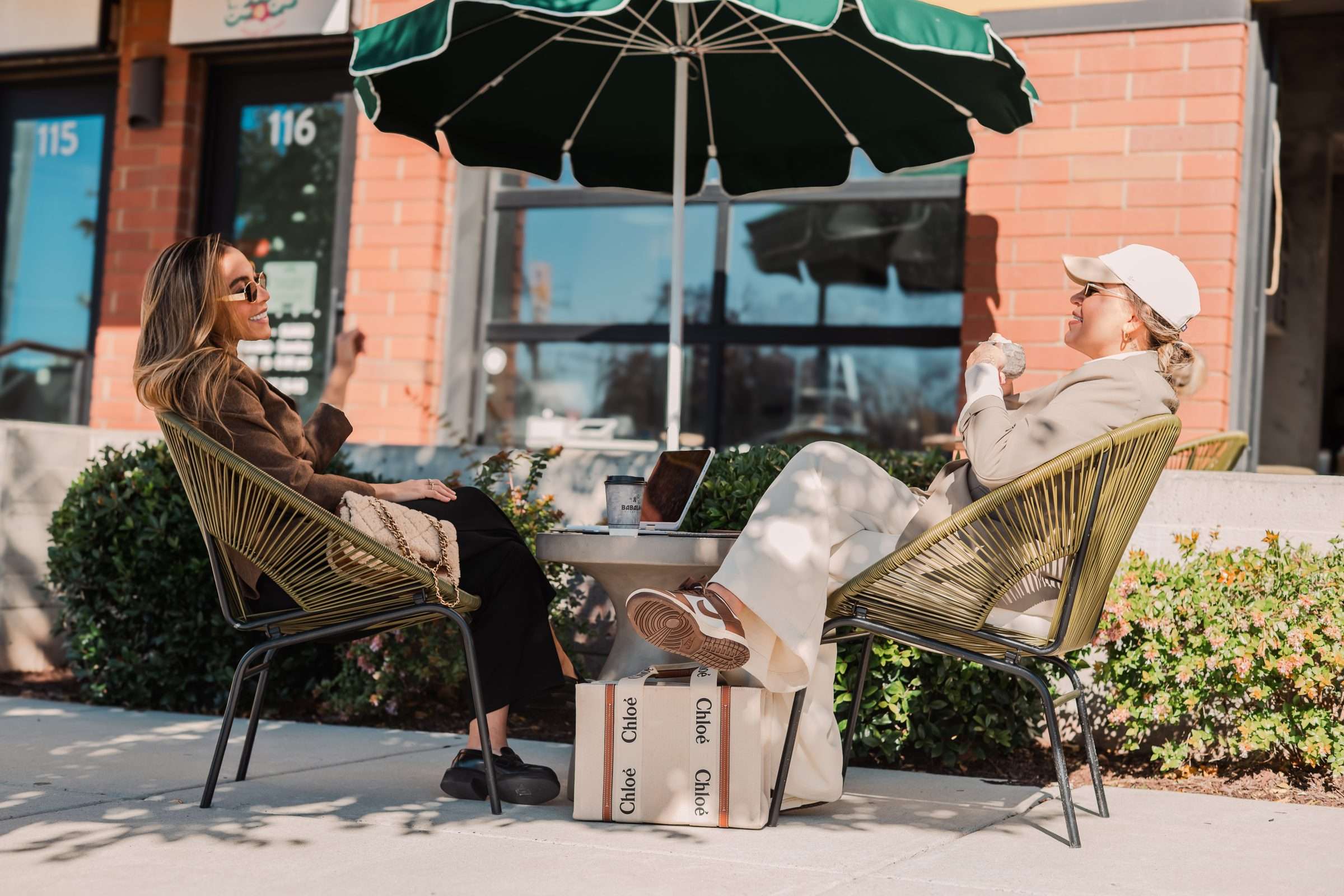 Guests relaxing under a green umbrella outside Babaloo