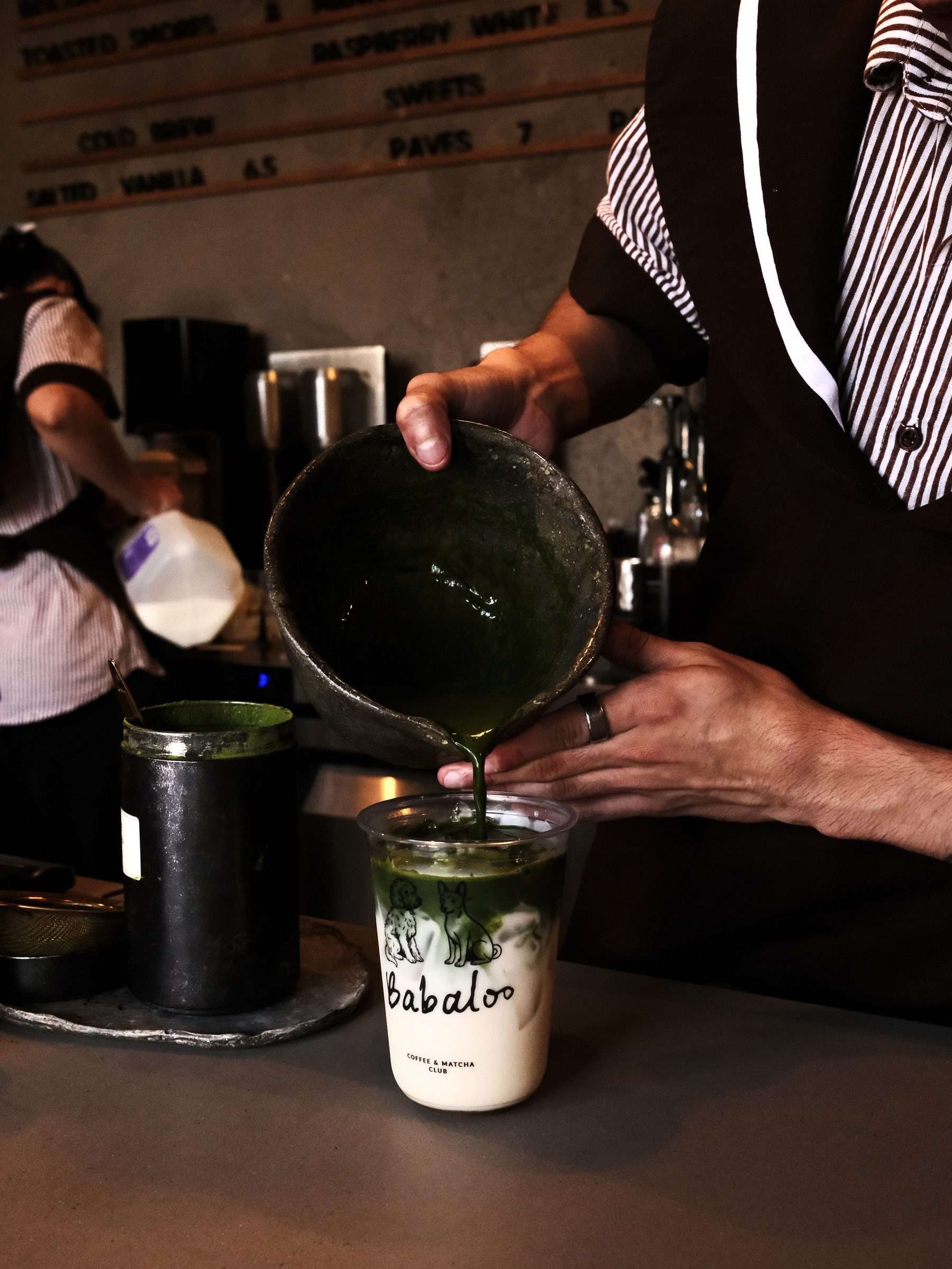 Barista pouring matcha into a Babaloo to-go cup