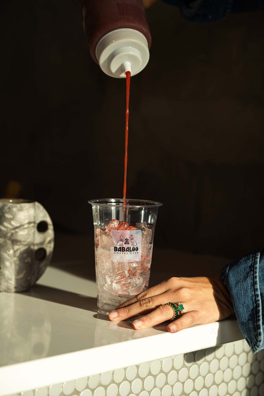 Berry syrup poured into an iced drink
