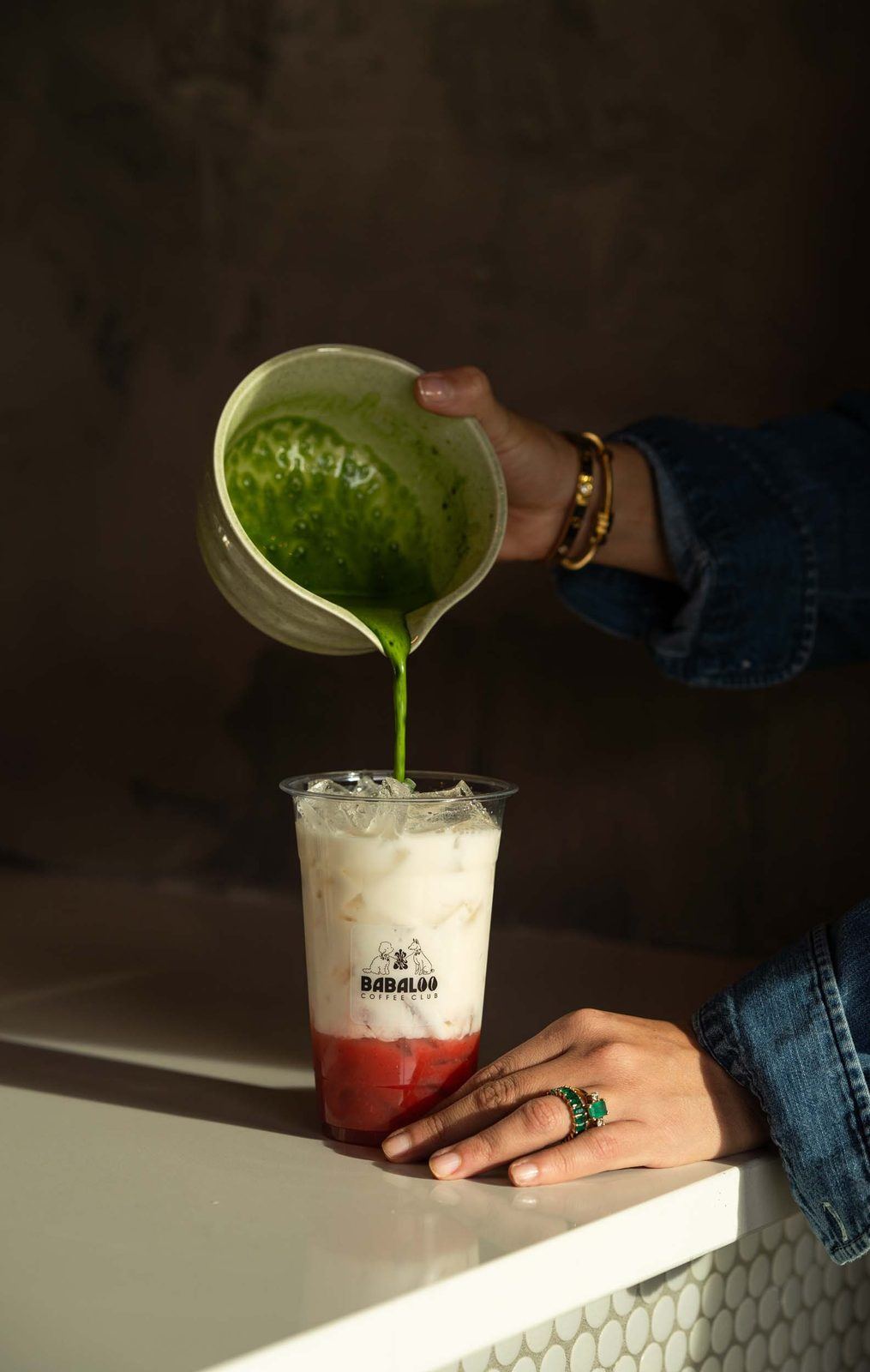 Matcha poured over strawberry puree and ice